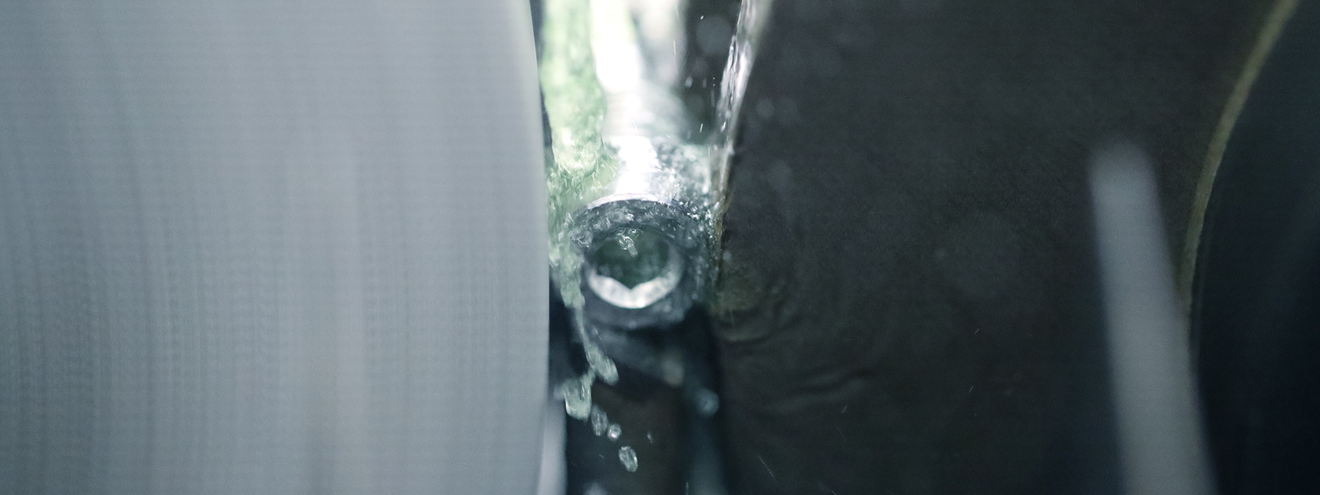 Detailaufnahme einer Metallschraube bei der mechanischen Nachbearbeitung in einer industriellen Fertigungsanlage.